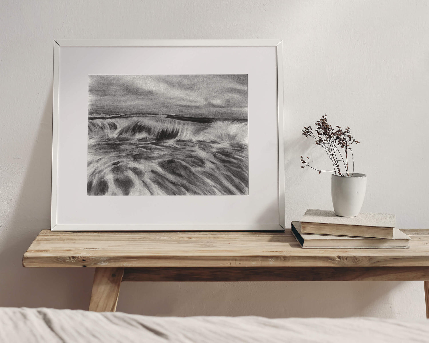 Original art, titled La Mar, hand-drawn with graphite and willow charcoal on fine art paper, by Australian artist, Hayley Byron. The drawing is a depiction of a wave in the ocean. This image features the artwork in-situ, in an interior bedroom.