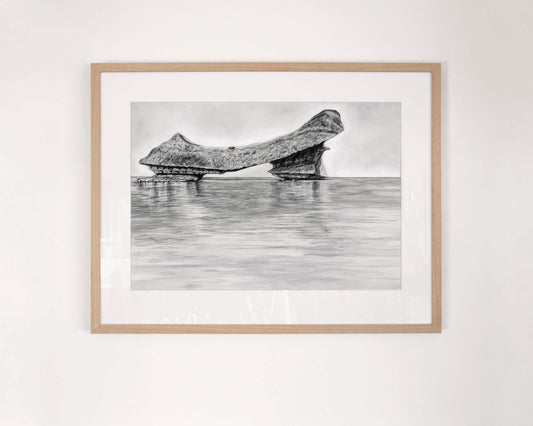 Original art, titled Grit, hand-drawn with graphite on fine art paper, by Australian artist, Hayley Byron. The drawing is a depiction of an iceberg, with water in the foreground. This image features the artwork in-situ, on a wall in a custom-made frame.