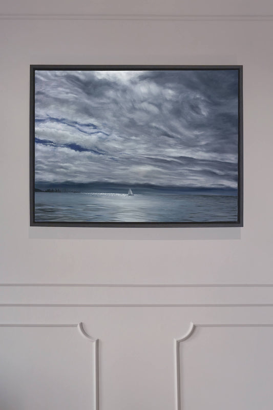Original art, titled Yesterday, painted in oil on canvas, by Australian artist, Hayley Byron. The painting is a depiction of a ship sailing on the ocean at Burleigh Heads, in a rain storm, with high-rise buildings in the distance. This image features the artwork in-situ, on a wall in a custom-made frame.