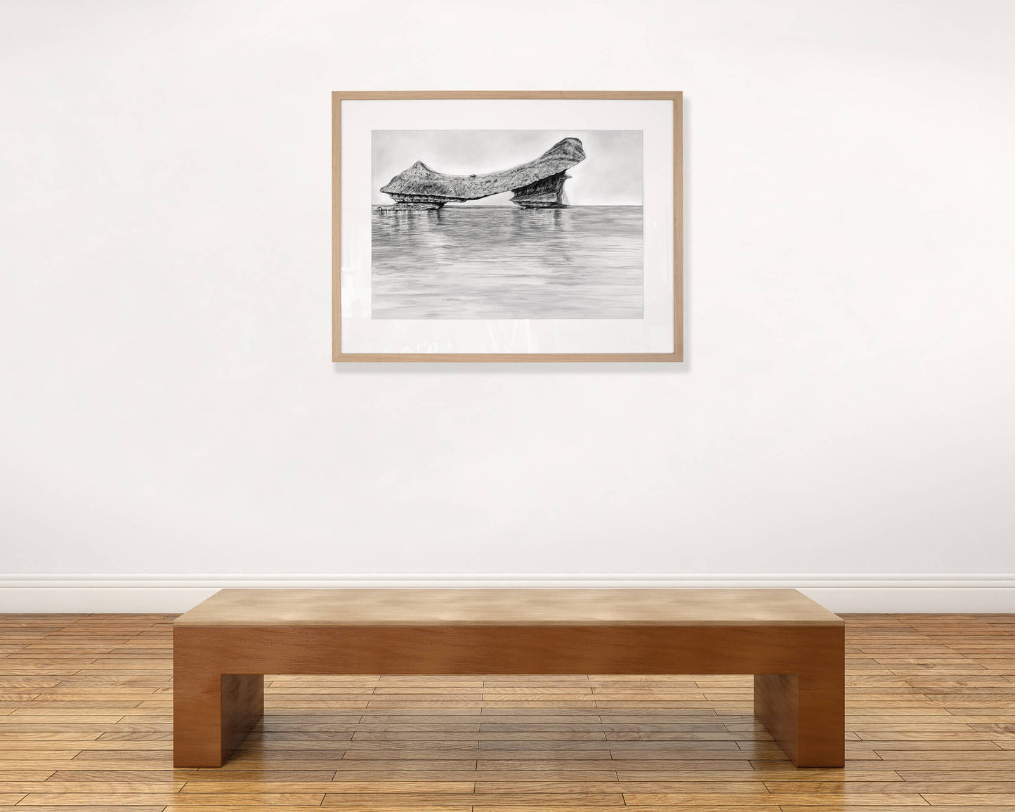 Original art, titled Grit, hand-drawn with graphite on fine art paper, by Australian artist, Hayley Byron. The drawing is a depiction of an iceberg, with water in the foreground. This image features the artwork in-situ, on a wall in an art gallery.