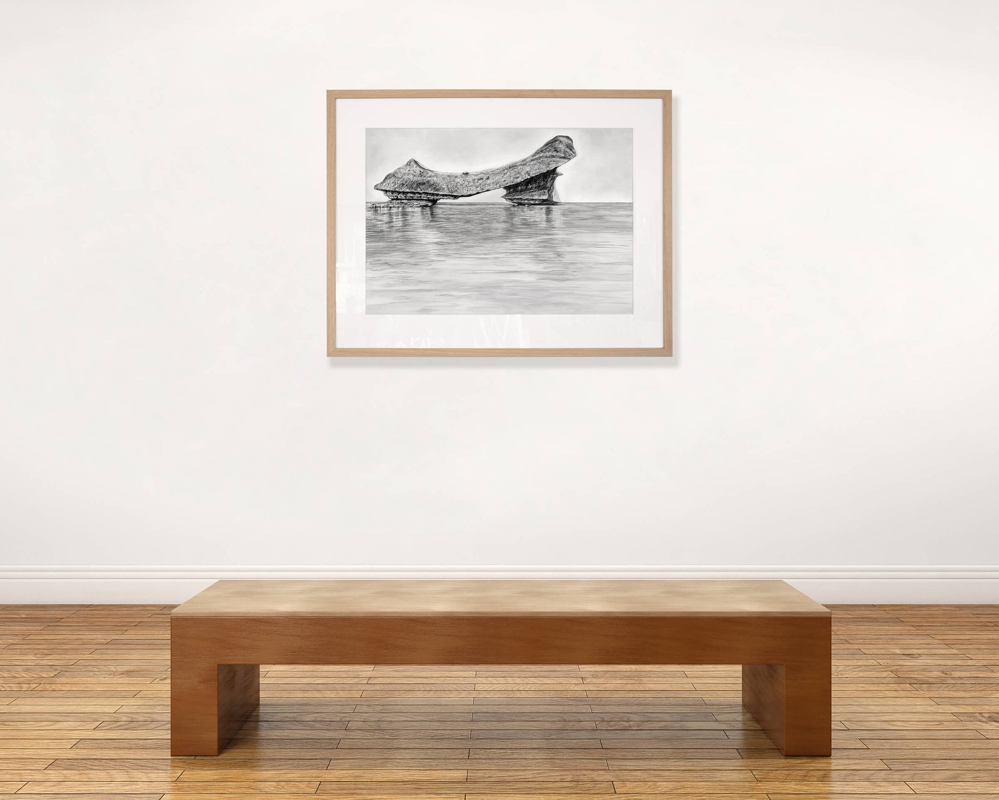 Original art, titled Grit, hand-drawn with graphite on fine art paper, by Australian artist, Hayley Byron. The drawing is a depiction of an iceberg, with water in the foreground. This image features the artwork in-situ, on a wall in an art gallery.